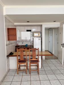 a kitchen with a wooden table and two chairs at Flat Vintage in Ribeirão Preto +2 photos