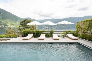 een zwembad met ligstoelen en parasols bij Ruby Como Villa with Lake View By Petra Luxury in Laglio