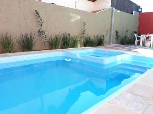 a blue swimming pool in front of a building at Pousada TOP Mairiporã in Mairiporã