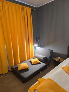 a bedroom with a bed and a couch with yellow pillows at Corso Studio 1 in Focşani