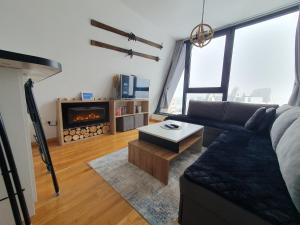 a living room with a couch and a fireplace at Apartment Dalia with a great view in Bjelašnica