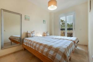 a bedroom with a large bed and a mirror at Luxury and first line apartment in Benalmádena +25 photos