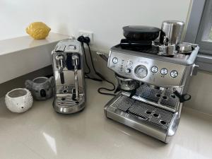 una macchinetta del caffè seduta su un bancone accanto a un tostapane di Vue De Vague a Lorne