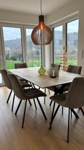 a dining room table with chairs and a large light fixture at Haus im Weinberg in Ellenz-Poltersdorf +44 photos