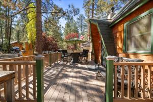 eine Terrasse mit einem Tisch und Stühlen auf einem Haus in der Unterkunft Big Bear Mountain Retreat with Hot Tub by MariamsBnb in Big Bear City Airport
