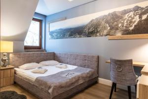 a bedroom with a bed and a painting on the wall at TatryTop Zakopiańskie Tarasy Premium & SPA in Zakopane