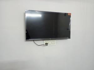 a flat screen tv hanging on a wall at Aditya Lodge in Warangal