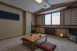 a living room with a table and a large window at Snow Freak Sunrise in Zao Onsen