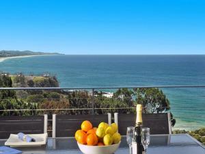 庫魯海灘的住宿－庫拉姆波恩特酒店，一张桌子,上面放着一碗水果和一瓶葡萄酒