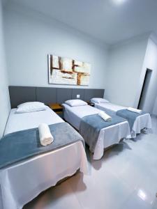 een kamer met drie bedden op rij bij Salinas House Hotel - Antigo Valley Hills Hotel in Salinas +15 foto's