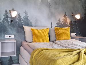 Un dormitorio con una cama con almohadas amarillas. en Ausblick Maisenbach, en Bad Liebenzell