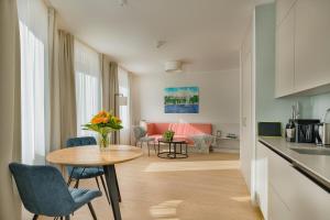 a kitchen and a living room with a table and chairs at Elisapart - Apartments am Sommerschloss in Potsdam