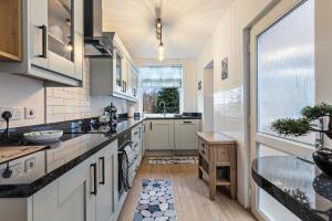 a kitchen with white cabinets and a large window at Pass the Keys Lovely Home in York with Parking in York