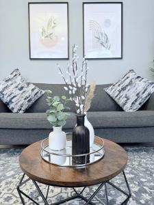 einen Couchtisch mit einer schwarzen Vase darauf in der Unterkunft StayLondon - Sleeps 5 with Free Parking - best for Holiday, Concerts or Matches in London