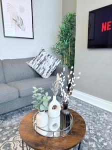 ein Wohnzimmer mit einem Sofa und einem Tisch mit Vasen in der Unterkunft StayLondon - Sleeps 5 with Free Parking - best for Holiday, Concerts or Matches in London