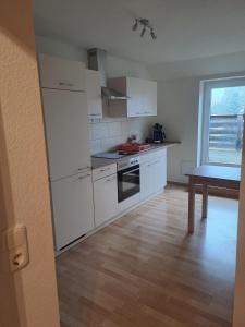 a kitchen with white appliances and a wooden floor at Zum-Rudi in Halberstadt +9 photos