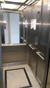 a bathroom with stainless steel walls and a mirror at Coral de Madryn in Puerto Madryn