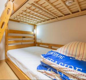 a bedroom with a bunk bed with blue pillows at あり宿 西九条20人合宿 Usjユニバ 京セラドーム 海遊館 観覧車 レゴ in Osaka