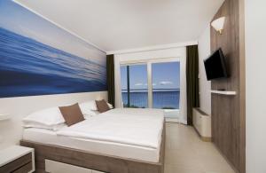 una camera da letto con un letto con vista sull'oceano di Bluesun hotel Neptun - All inclusive a Tučepi