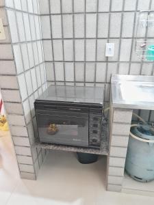 a toaster oven on a shelf in a kitchen at Guarapari com elevador, reformado, Wi-Fi, TV com Smart, vista livre e estacionamento in Guarapari +9 photos
