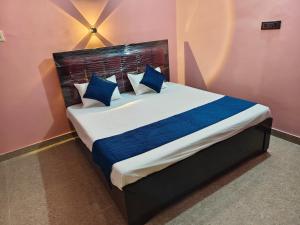 um quarto com uma cama grande com travesseiros azuis em Dev Paradise Ayodhya em Ayodhya
