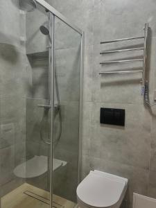 a bathroom with a shower and a toilet in it at МІАМО студіо з терасою in Lviv