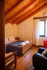 Agnes Cottage House في كونيتسا: غرفة نوم بسرير في غرفة بسقوف خشبية