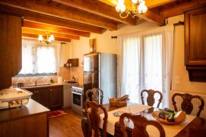 a kitchen with a table and chairs and a kitchen with a kitchen at Agnes Cottage House in Konitsa