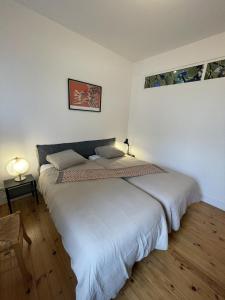 a bedroom with a large white bed in a room at Maison de ville avec terrasse in La Rochelle