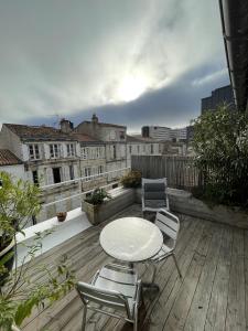 a patio with a table and chairs on a balcony at Maison de ville avec terrasse in La Rochelle