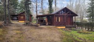 a small wooden cabin in a forest with a driveway at Cabañas Lothlorien in Villa Yacanto
