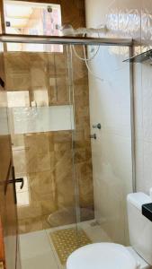 a glass shower in a bathroom with a toilet at Aconchego in Pôrto Santana