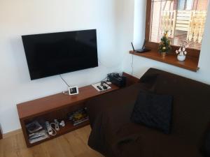 a living room with a couch and a flat screen tv at Apartmán pod Tatrami B207 in Veľká Lomnica
