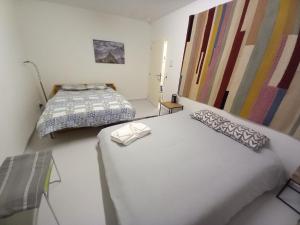 a bedroom with two beds and paintings on the wall at Chez Jean-Claude Chambre 4 personnes in Wavre
