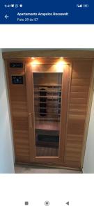 an image of a wooden cabinet with a microwave at Apartamento Acapulco in Punta del Este +18 photos