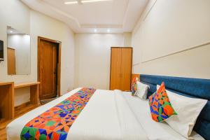 a bedroom with a large bed and a television at FabHotel Alpine Tree in Amritsar
