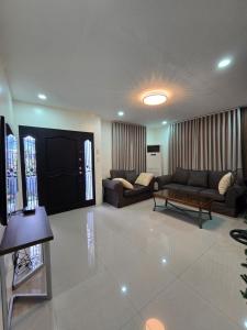 a large living room with couches and a tv at Sunny at DJE Villa in Angeles