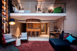 a living room with a couch and chairs and a kitchen at Ovolo Woolloomooloo in Sydney