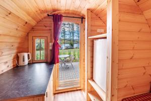 a wooden cabin with a door leading to a patio at Camping u Kukačků in Horní Planá