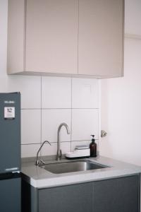 a kitchen with a sink and a refrigerator at NEW The Sun 3Bedrooms 10pax 2CP in Bayan Lepas +61 photos