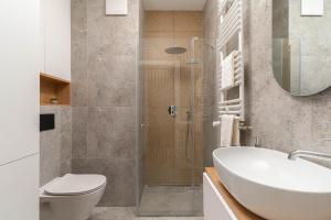 une salle de bain avec un lavabo, des toilettes et une douche dans l'établissement Apartamenty Falista Łódź Retkinia, à Łódź 43 autres photos
