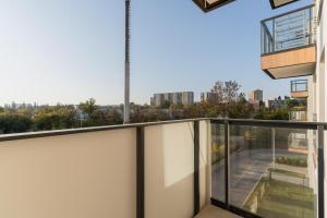 un balcon avec vue sur la ville dans l'établissement Apartamenty Falista Łódź Retkinia, à Łódź
