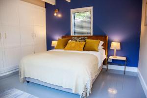 a blue bedroom with a large bed with yellow pillows at Sunset Villa in Scarborough