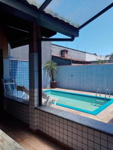 a swimming pool on the side of a building at Pousada Muzeli in Itanhaém