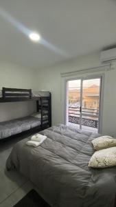 コスキンにあるApart Buena Vista Cosquín - Departamentos en pleno centroの大きなベッドと窓のある寝室