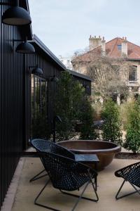 a patio with two chairs and a large tub at Hôtel Lilybloom in Le Havre