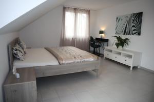 a bedroom with a bed and a desk and a window at Dream Home in Renningen