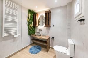 a bathroom with a sink and a toilet and a mirror at Apollon Suite in Thessaloniki +22 photos