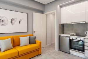 a living room with an orange couch and a kitchen at Aire in Tripoli