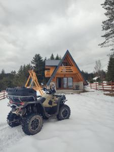 a atv parked in the snow in front of a cabin at Vikendica Monte Pino Romanija in Sokolac